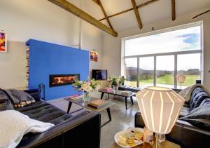 a living room with a couch and a fireplace at Blue Tile Farm Barn in Saxlingham