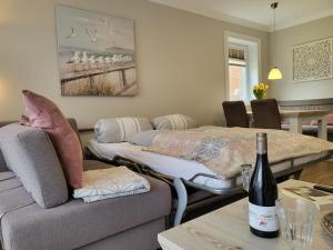 ein Wohnzimmer mit 2 Betten und einer Flasche Wein auf der Couch in der Unterkunft Apartment 79 im Haus Villa Anna II in Sankt Peter-Ording