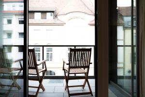 2 Stühle auf einem Balkon mit Blick aus dem Fenster in der Unterkunft Welcome to Paradies - Ferienwohnung von Privat in Konstanz