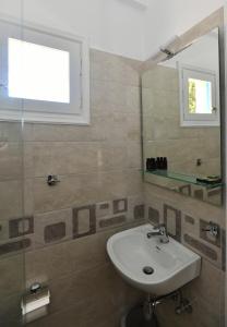 La salle de bains est pourvue d'un lavabo et d'un miroir. dans l'établissement Vanas Apartments, à Spetses