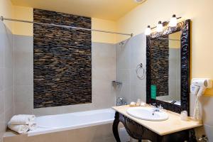 a bathroom with a sink and a bath tub and a mirror at Hotel Central Park Sighisoara in Sighişoara