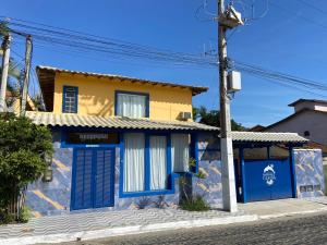 a house with blue and yellow doors on a street at Pousada Maresias de Geribá in Búzios