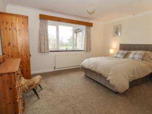 a bedroom with a bed and a window and a desk at Hawksbridge Bungalow in Macclesfield