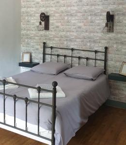 a bed in a bedroom with a brick wall at Le moulin de Clauzure - Périgord vert in Saint-Paul-Lizonne
