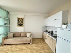 a living room with a couch and a kitchen at Despacito Port Side in Vlorë
