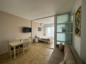 a living room with a couch and a dining room at Despacito Port Side in Vlorë