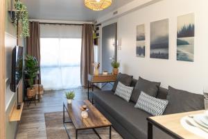 a living room with a couch and a table at Le Nordik proche aéroport CDG I Paris I Astérix in Dammartin-en-Goële