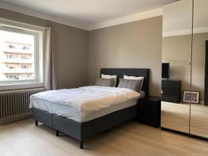 - une chambre avec un grand lit et une fenêtre dans l'établissement Ferieleiligheter i Kristiansand, à Kristiansand