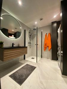 La salle de bains est pourvue d'une douche, d'un lavabo et d'un miroir. dans l'établissement Ferieleiligheter i Kristiansand, à Kristiansand