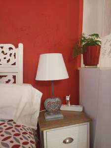 un lit avec une table et une lampe. dans l'établissement Studio le coquelicot, à Cotignac