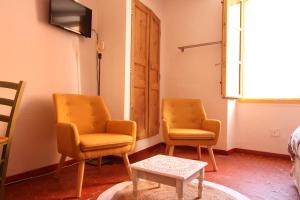 2 Stühle und ein Tisch in einem Zimmer in der Unterkunft Studio le coquelicot in Cotignac