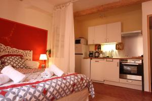 eine kleine Küche mit einem Bett in einem Zimmer in der Unterkunft Studio le coquelicot in Cotignac