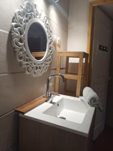 La salle de bains est pourvue d'un lavabo blanc et d'un miroir. dans l'établissement Studio le coquelicot, à Cotignac