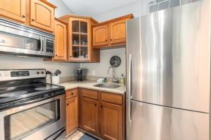 a kitchen with wooden cabinets and a stainless steel refrigerator at Arrowhead Resort in Saugatuck