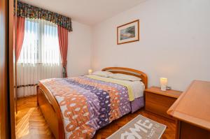 a bedroom with a bed and a dresser and a window at Apartments Palma in Rovinj