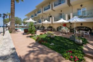 a hotel with tables and chairs and umbrellas at Kalyves Beach Hotel in Kalyves