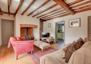 a living room with a couch and a fireplace at Bridge Cottage in North Creake