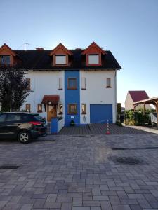 een wit en blauw huis met een parkeerplaats bij Sonniges Fleckchen in Griesheim