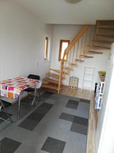 a living room with a table and a staircase at Sonniges Fleckchen in Griesheim