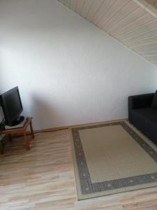 a living room with a tv and a couch and a table at Sonniges Fleckchen in Griesheim