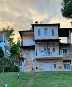 a large house with a staircase in front of it at Serenity Apartment in Paliouri in Paliouri