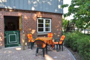 a table and chairs in front of a brick building at Hof Tummetott in Mittelangeln