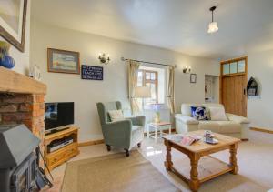a living room with a couch and a fireplace at Carrstone Cottage in Grimston