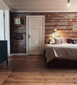 a bedroom with a bed and a wooden wall at Pensionatet in Piteå