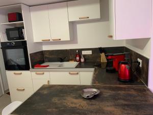 a kitchen with white cabinets and a red appliance at Maison entière avec sauna privatif Sauna sur Sye in Aouste-sur-Sye