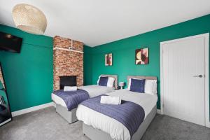 2 camas en una habitación con paredes verdes en Luxnightzz - Central 3 Bed House Parking, en Colchester