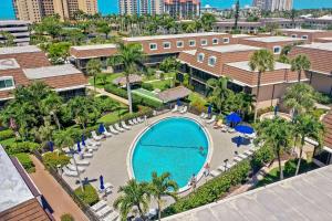 an overhead view of a pool with palm trees and buildings at Quaint condo steps to the beach and dining in Marco Island