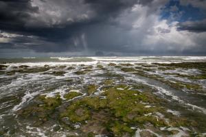 a beach with a stormy sky and the ocean at Los Palos Ribera Norte in Playa Unión