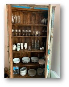 um armário cheio de pratos, copos e pratos em Gorgeous Beach Villla with AC, 300m2 from Playa Mitjorn em Es Migjorn