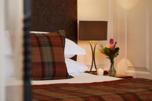 a bedroom with a bed with a pillow and a lamp at Macdonald Elmers Court Resort in Lymington