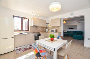 a kitchen and dining room with a white table and chairs at Apartments Palma in Rovinj