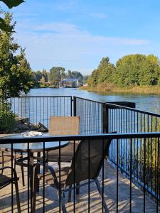 einen Tisch und Stühle auf einem Balkon mit Flussblick in der Unterkunft Cabañas Rosner in Valdivia