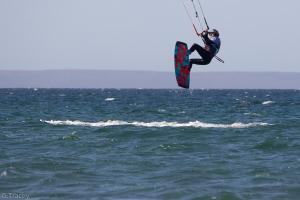 una persona está en el aire sobre el océano en Los palos Ribera Norte 2 en Playa Unión