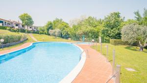 einen Pool in einem Park mit Bäumen und Häusern in der Unterkunft La Casa sulla Collina - Italian Homing in Padenghe sul Garda