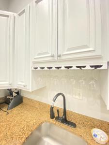 una cocina con armarios blancos y fregadero en Large DUPLEX Apt 2Bdrm 1Den-Metro, en Washington