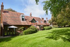 une maison avec une pelouse verte devant elle dans l'établissement Macdonald Elmers Court Resort, à Lymington