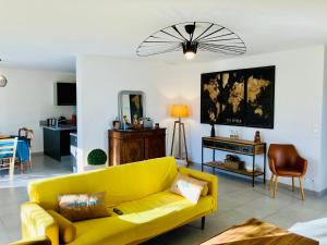 salon z żółtą kanapą i stołem w obiekcie Villa Carletti à 3min des plages (7pers. - 3ch.) w mieście Oletta
