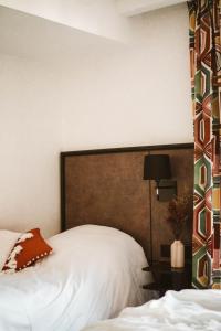 a bedroom with a bed with a headboard and a lamp at La Maison Montparnasse in Paris