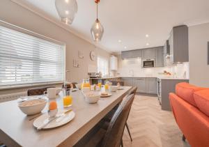 a kitchen and dining room with a long table with chairs at Curlew Cottage in Wells next the Sea