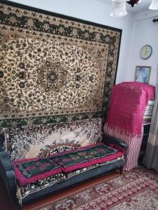 カラコルにあるGuest house SONO adress Derbisheva 202の椅子とラグの壁が備わる客室です。