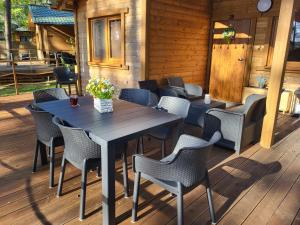 una terraza de madera con mesa y sillas en Dzik w zagrodzie en Borsk