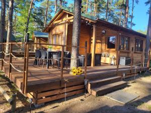 une cabine dans les bois avec une terrasse en bois dans l'établissement Dzik w zagrodzie, à Borsk