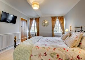 - une chambre avec un grand lit et une télévision murale dans l'établissement Cockleshells, à Castle Acre