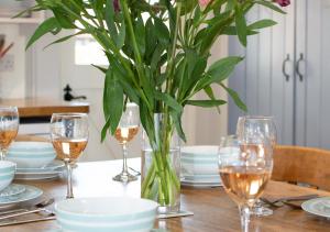 une table avec des verres et un vase avec une plante dans l'établissement Cockleshells, à Castle Acre