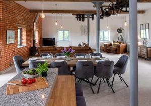 a dining room and living room with a brick wall at Cubitts in Witton
