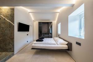 a bedroom with a bed and a tv on a wall at App 302 Palazzo Cavour in Bolzano